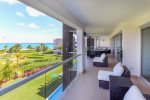 Ocean view terrace with Jacuzzi, lounge chairs, and patio table with seating for 8